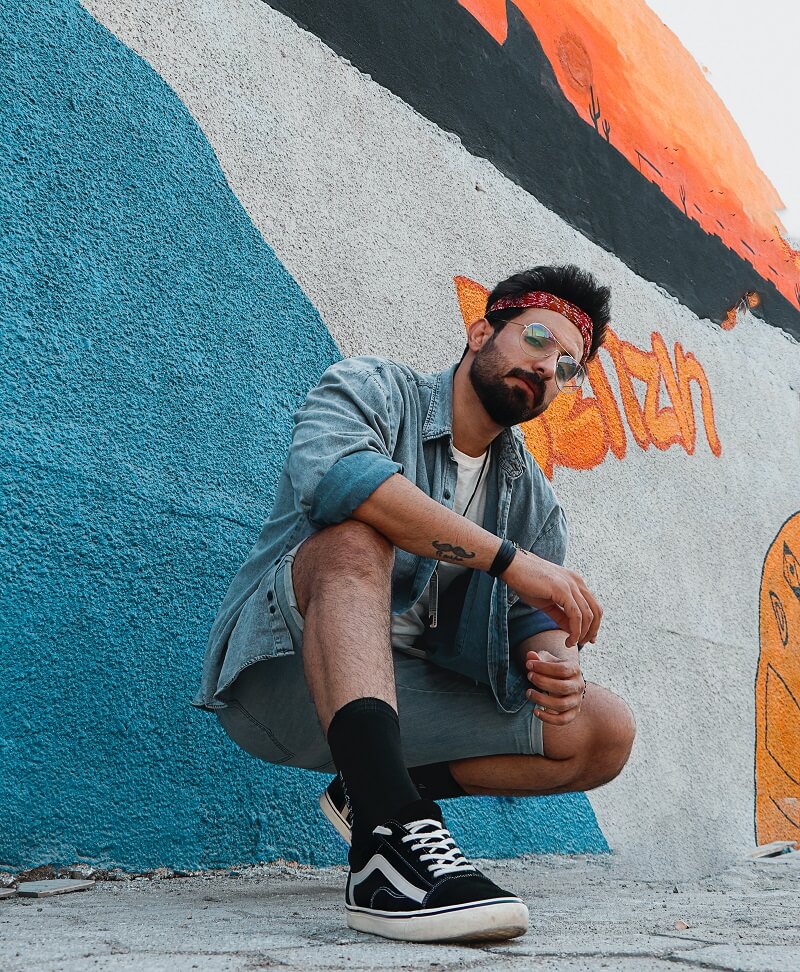 men wearing denim jacket with a printed shirt and shorts.
