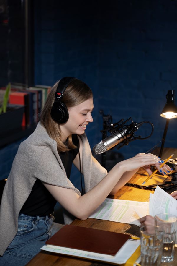 A woman wearing headphones and share the stories behind songs 