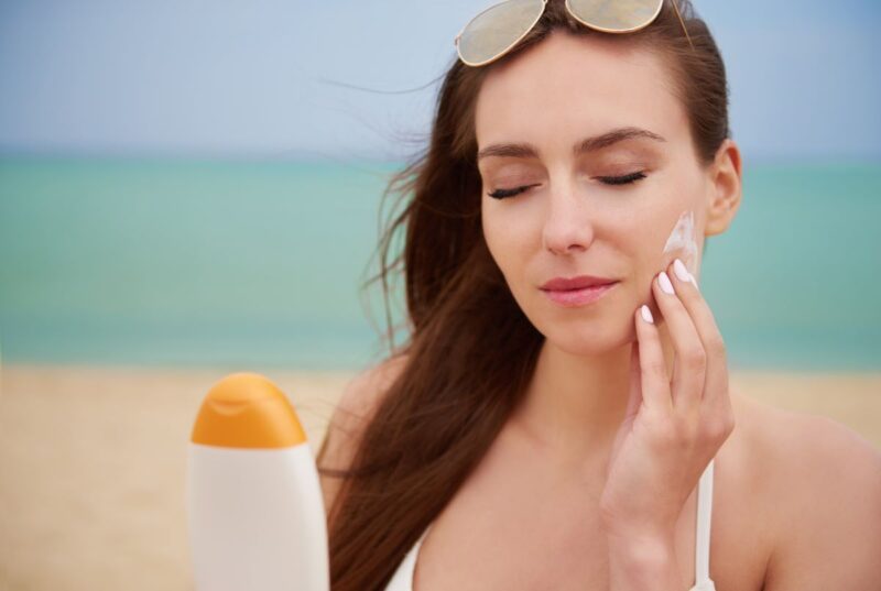 young beautiful woman applying sun cream for sun protection