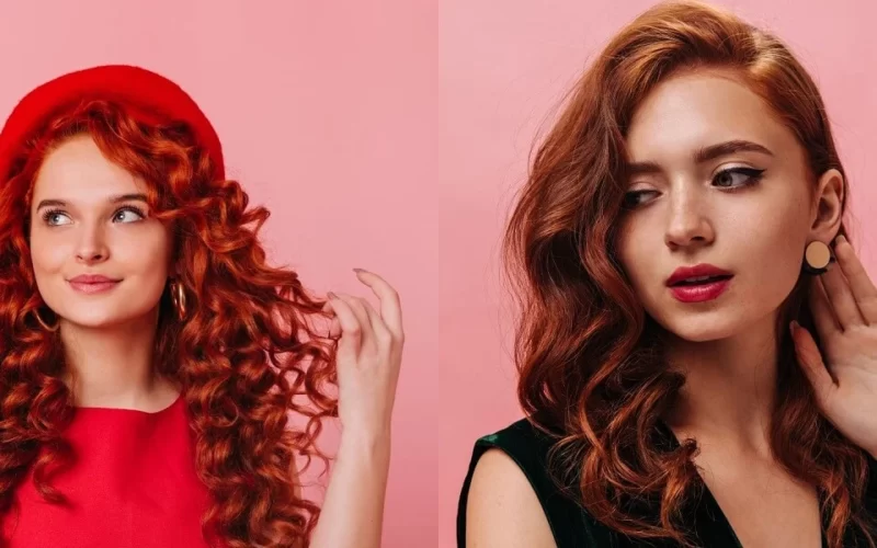 Two girls with red and black-red mix hair posing against a vibrant pink background.